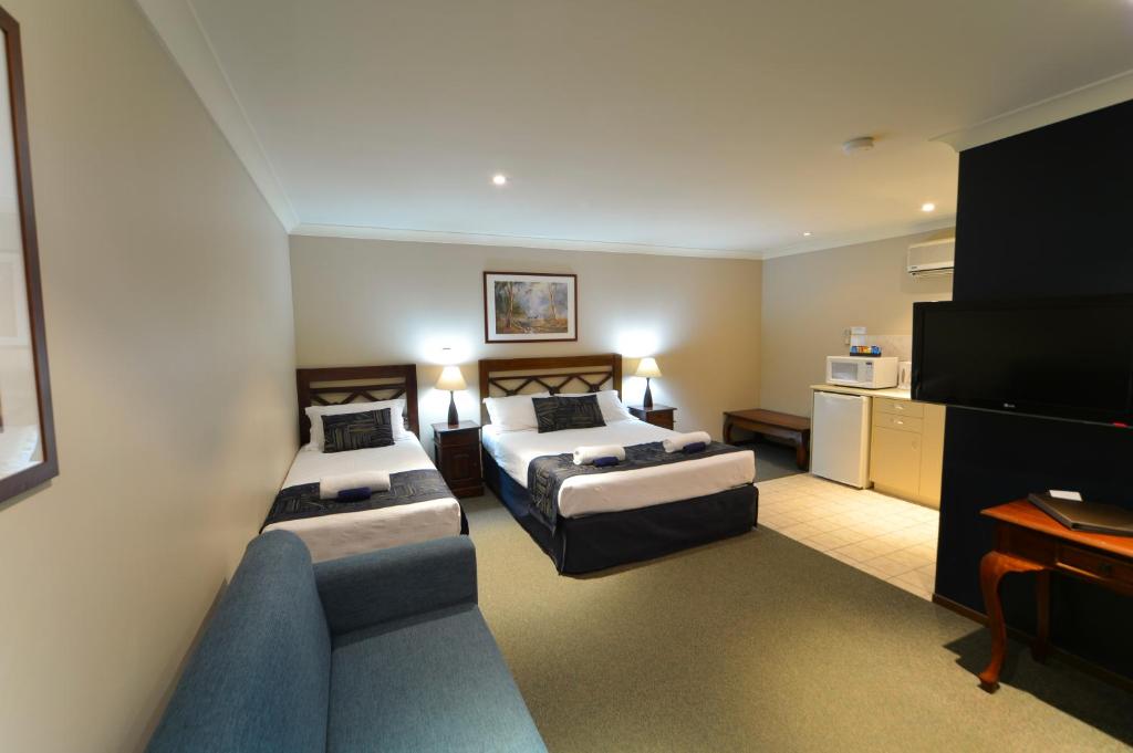 珀斯金合欢树林汽车旅馆的酒店客房,设有两张床和一张沙发