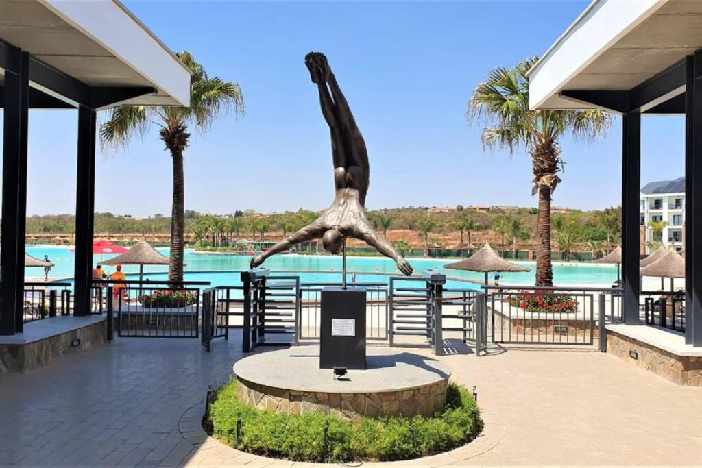 比勒陀利亚The Blyde - Morden 2 bedroom apartment的长颈鹿在游泳池前的雕像