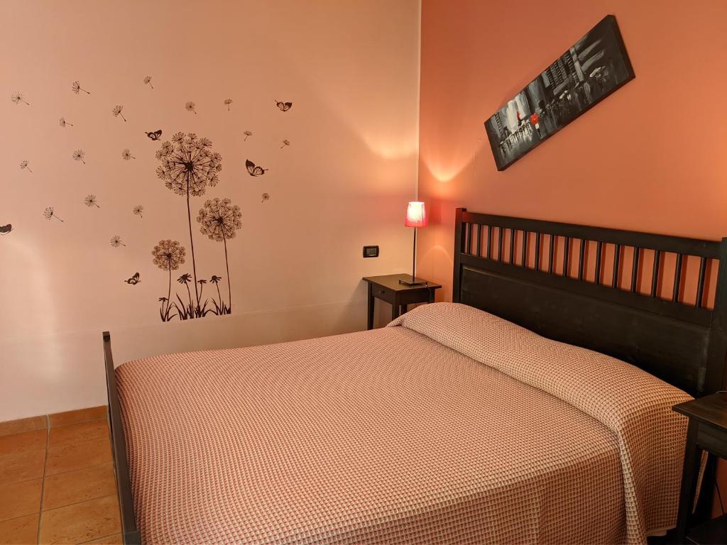 维罗纳La Buccetta B&B的卧室配有一张床,墙上挂着鲜花