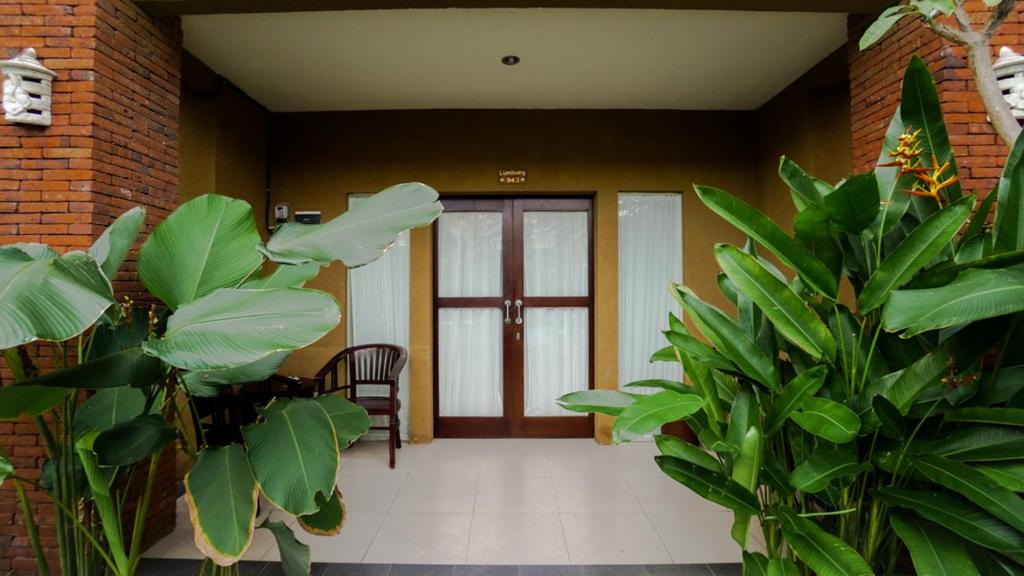沙努尔贾南别墅公寓的大堂设有门,种植了绿树
