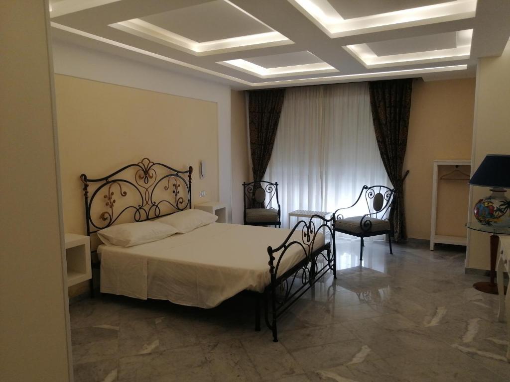 巴勒莫Federico 70 Zaffiro Luxury的一间卧室配有一张大床和两把椅子
