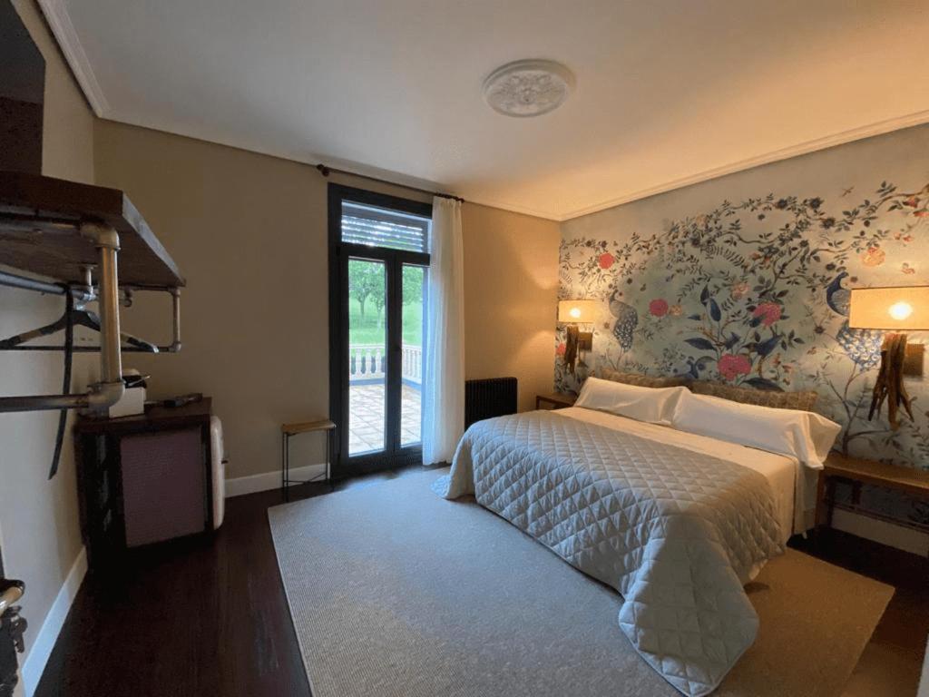 穆斯基斯La Casa DelBelga的一间卧室配有一张带花卉墙壁的床