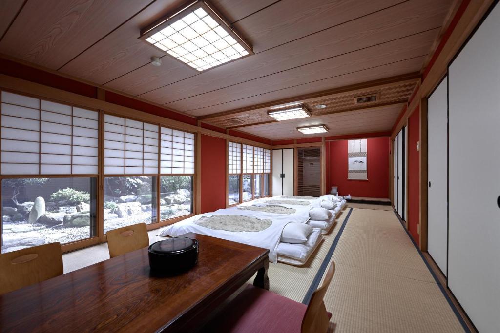 金泽山室日式旅馆的大型客房设有床、桌子和窗户。