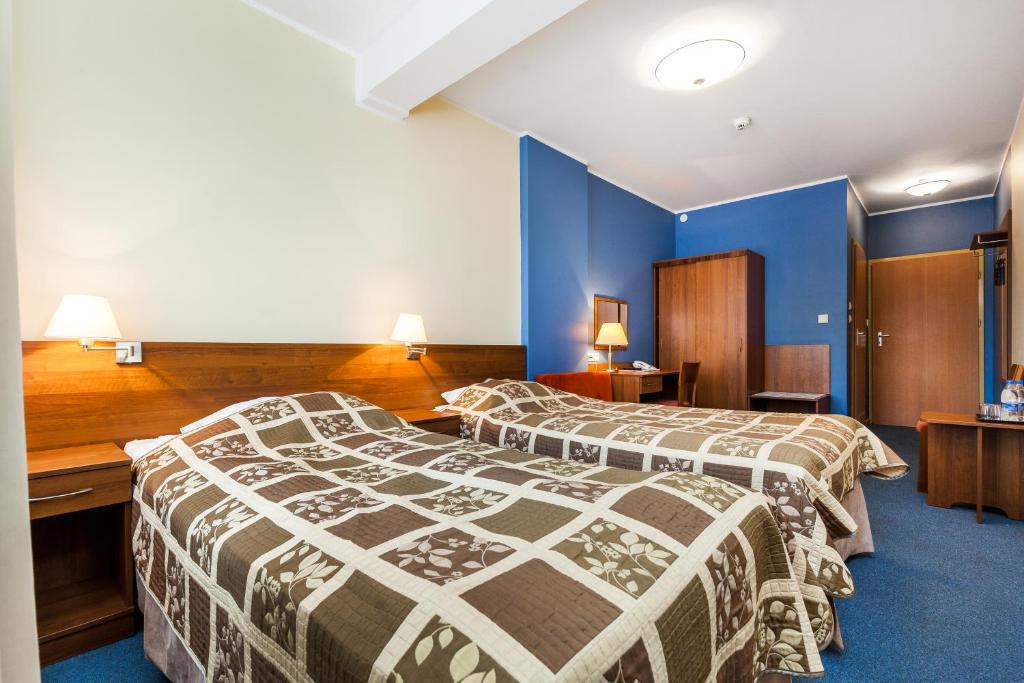 格但斯克奥利维亚酒店 的两张位于酒店客房的床,拥有蓝色的墙壁