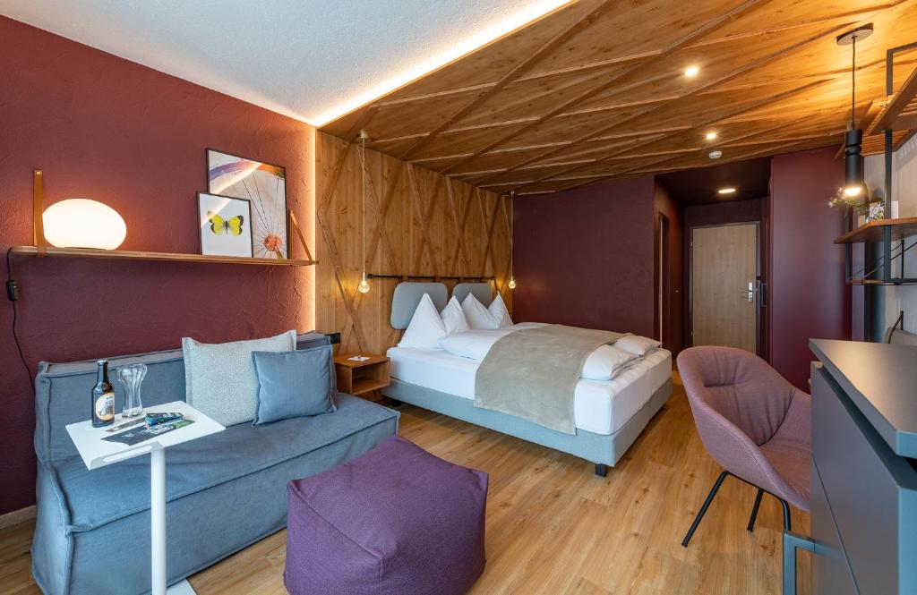 伦策海德Sunstar Hotel Lenzerheide的酒店客房,配有床和沙发