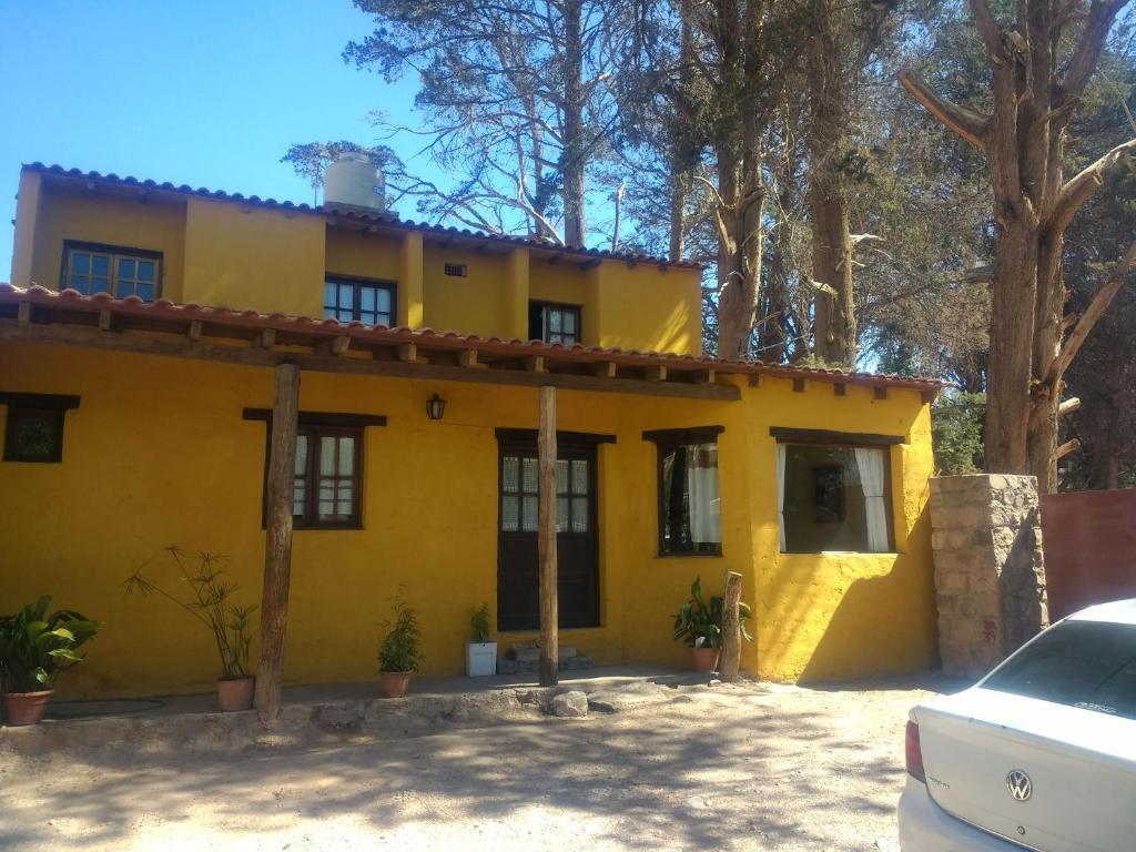 蒂尔卡拉La Casa de la Abuela Tilcara的一座黄色的房子,前面有一辆汽车