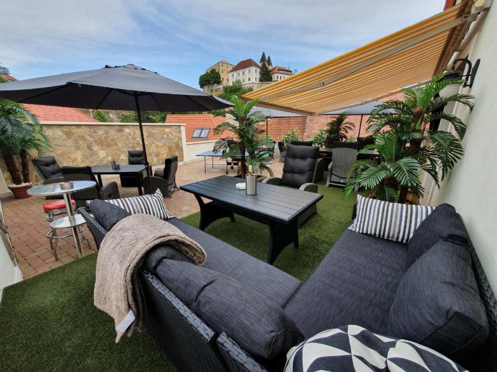 维斯普雷姆A-M Condominium的天井配有沙发、桌子和雨伞。