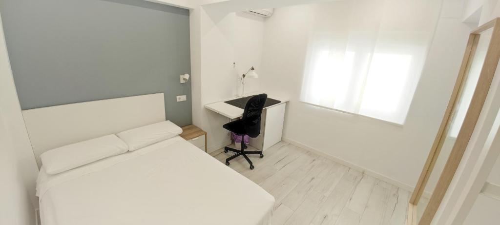 韦尔瓦Hispania House的一间卧室配有一张床、一张桌子和一把椅子