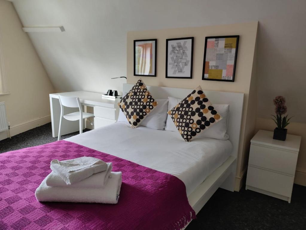利物浦Abbeyfield Guesthouse的一间卧室配有一张大床和紫色毯子
