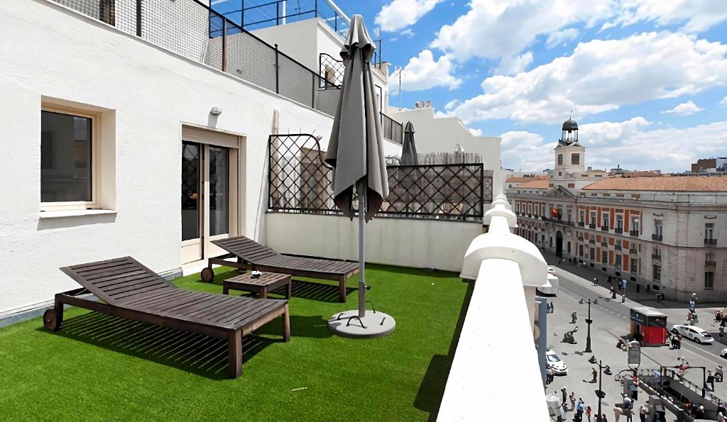 马德里Hotel Moderno Puerta del Sol的阳台设有长椅,享有城市美景。