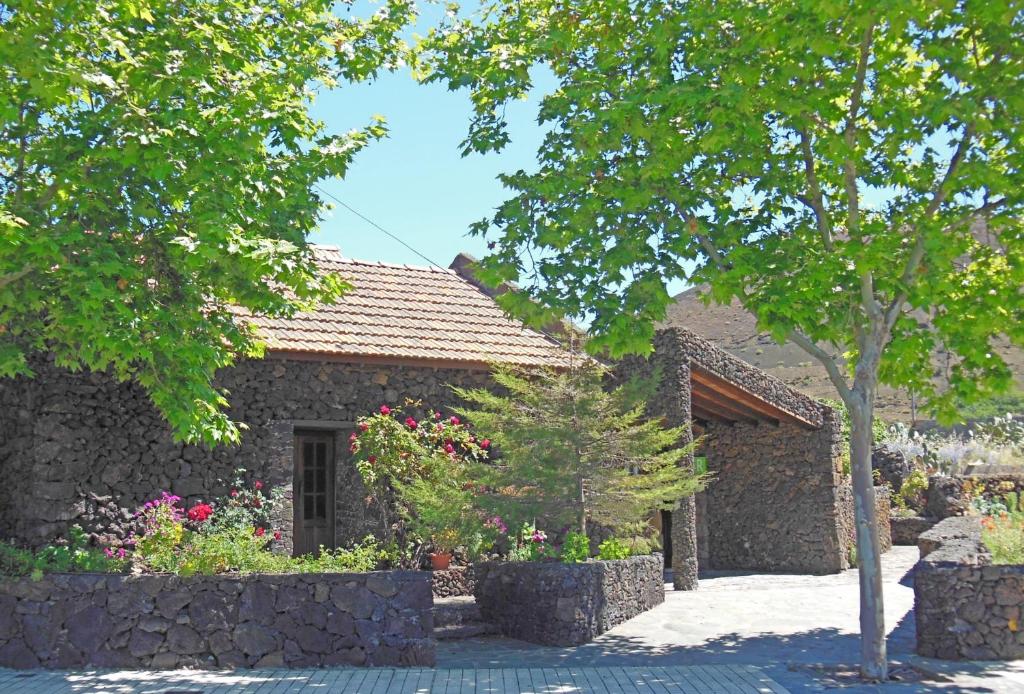 San Andrés阿博毕池卡萨乡间酒店的一座石头房子,设有花园和一棵树