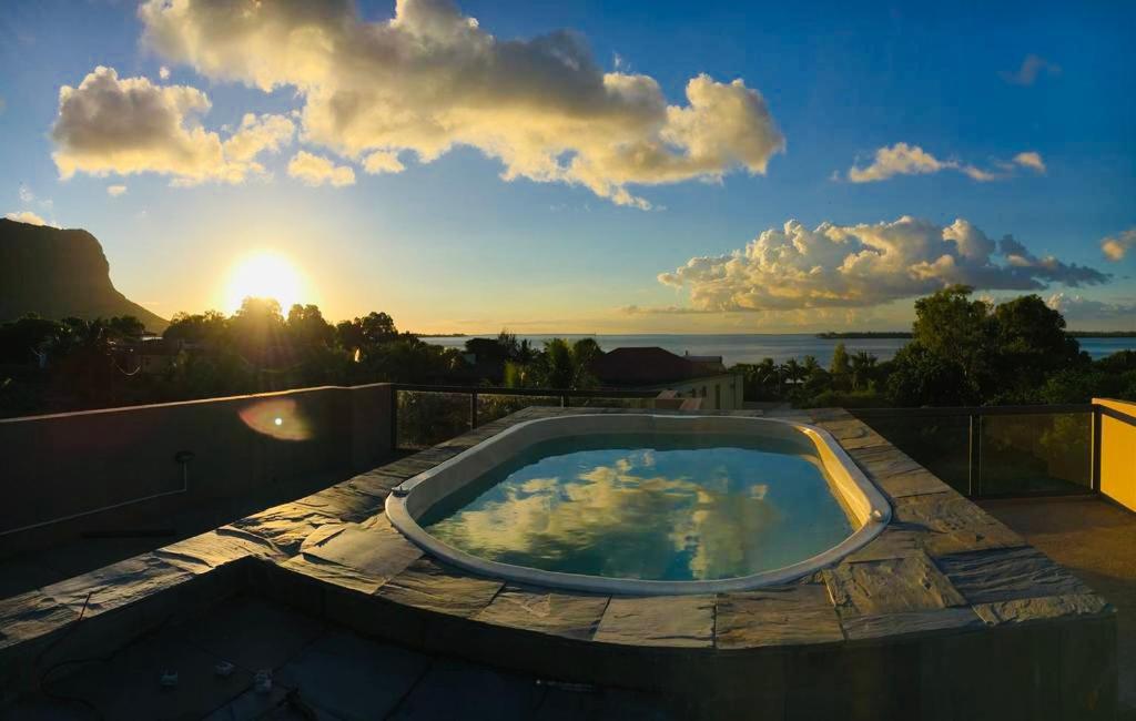 拉戈莱特Luxe Exotica Apartments的阳台上的热水浴池,享有日落美景