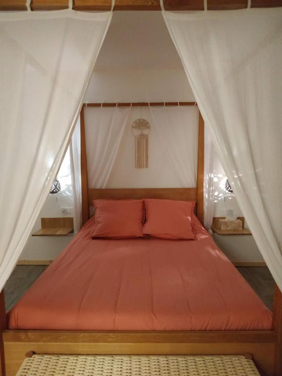 蒙特La ferme des Escampades的一张带橙色床罩的床