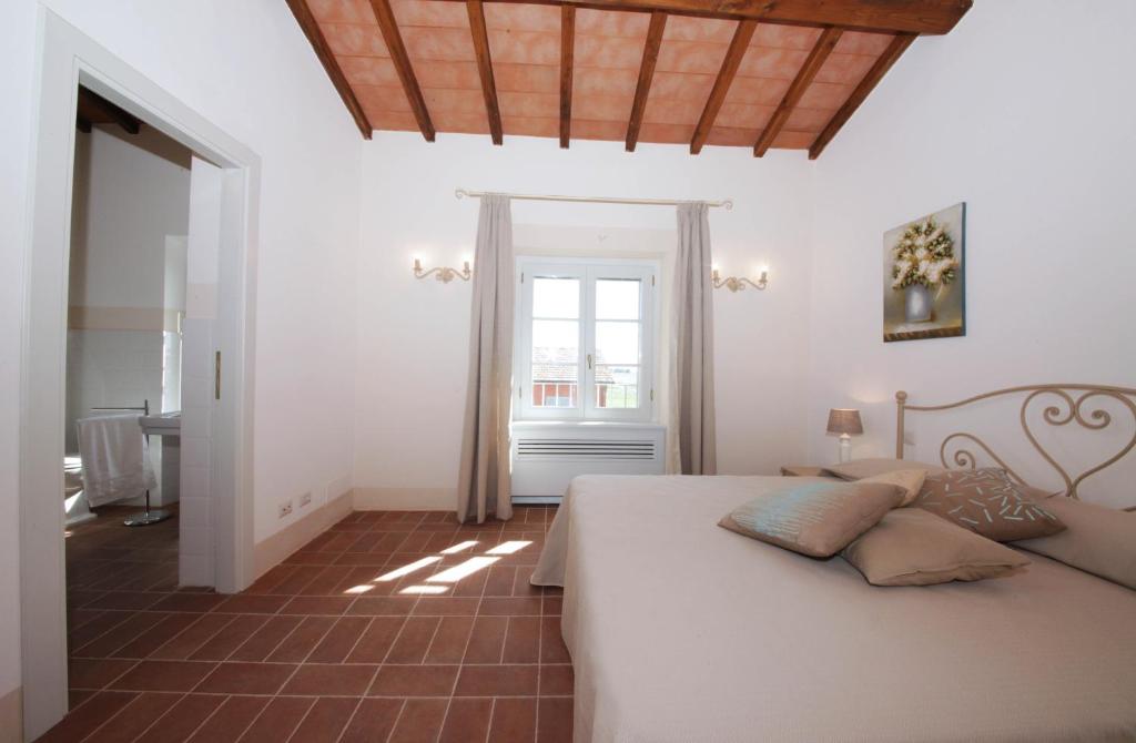 蒙塔尔托迪卡斯特罗皮安尼德拉玛琳娜乡村民宿的卧室配有白色的床和窗户。