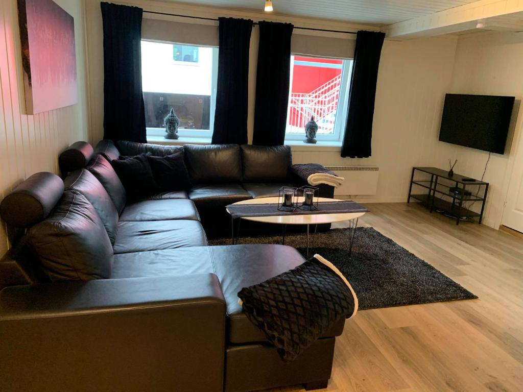诺托登Notodden Sentrum Apartment NO 1的客厅配有真皮沙发和桌子