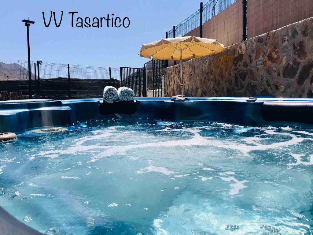 TasarticoVv Tasartico with hot tub的蓝色的热水浴池和雨伞