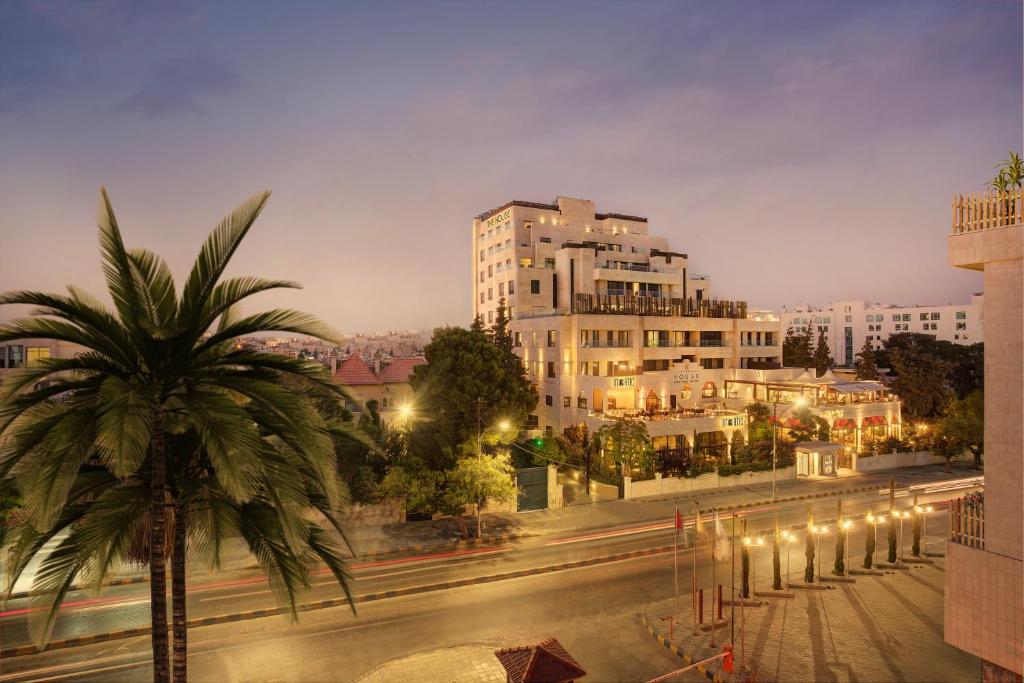 安曼豪斯精品套房酒店的一条拥有棕榈树和建筑的城市街道