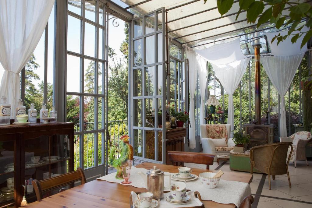 吉维尼勒普伊玫瑰酒店的温室配有桌椅和窗户