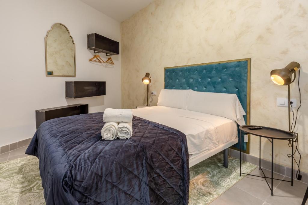 赫雷斯-德拉弗龙特拉Villamarta Boutique Rooms的一间卧室配有一张床,上面有两条毛巾