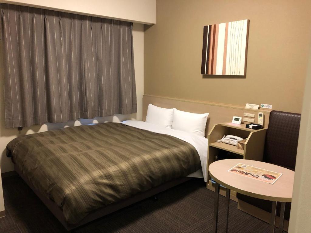 桥本桥本路特酒店的酒店客房配有一张床铺和一张桌子。