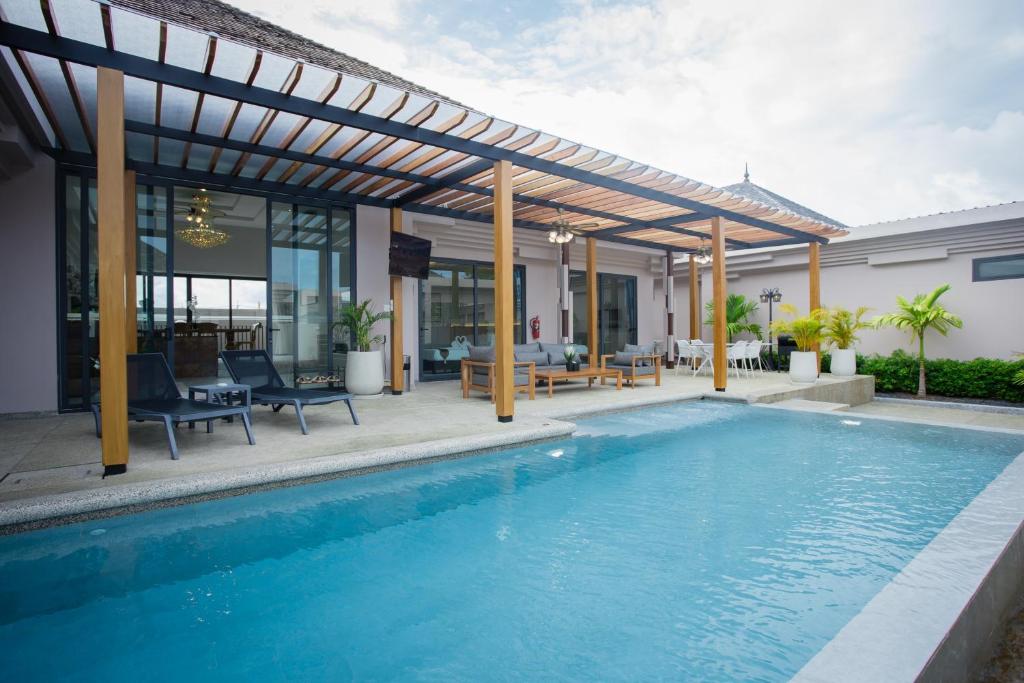 邦涛海滩Gold Chariot Pool Villa, Phuket - SHA Plus Certified的一座带凉亭的游泳池,位于一座房子旁边