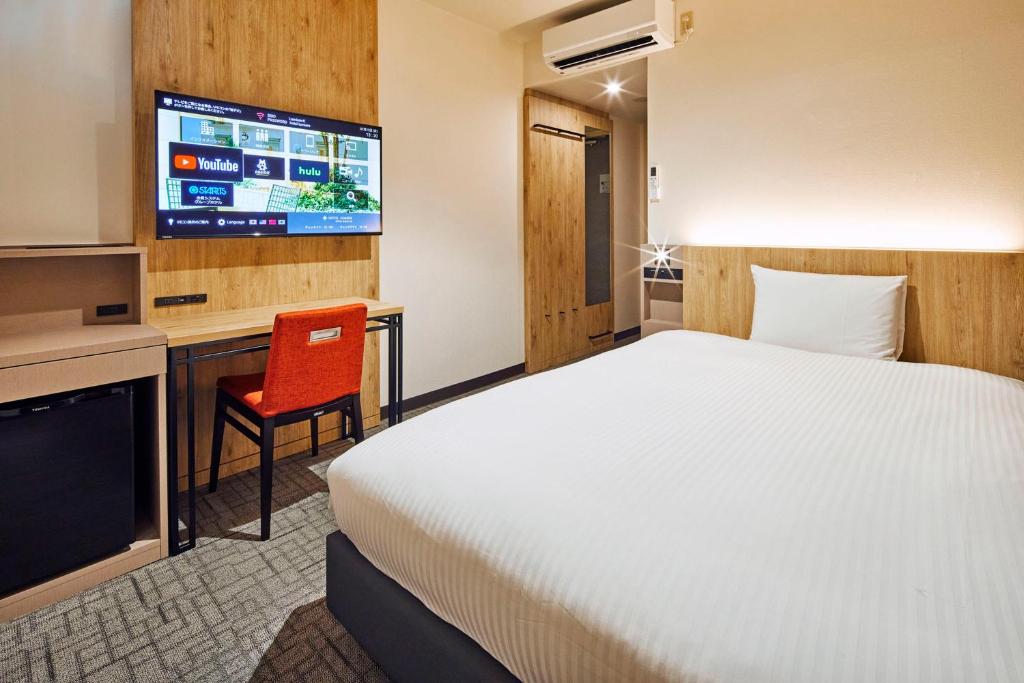 东京开赛卢米埃尔酒店的一间酒店客房,配有一张床和一台电视