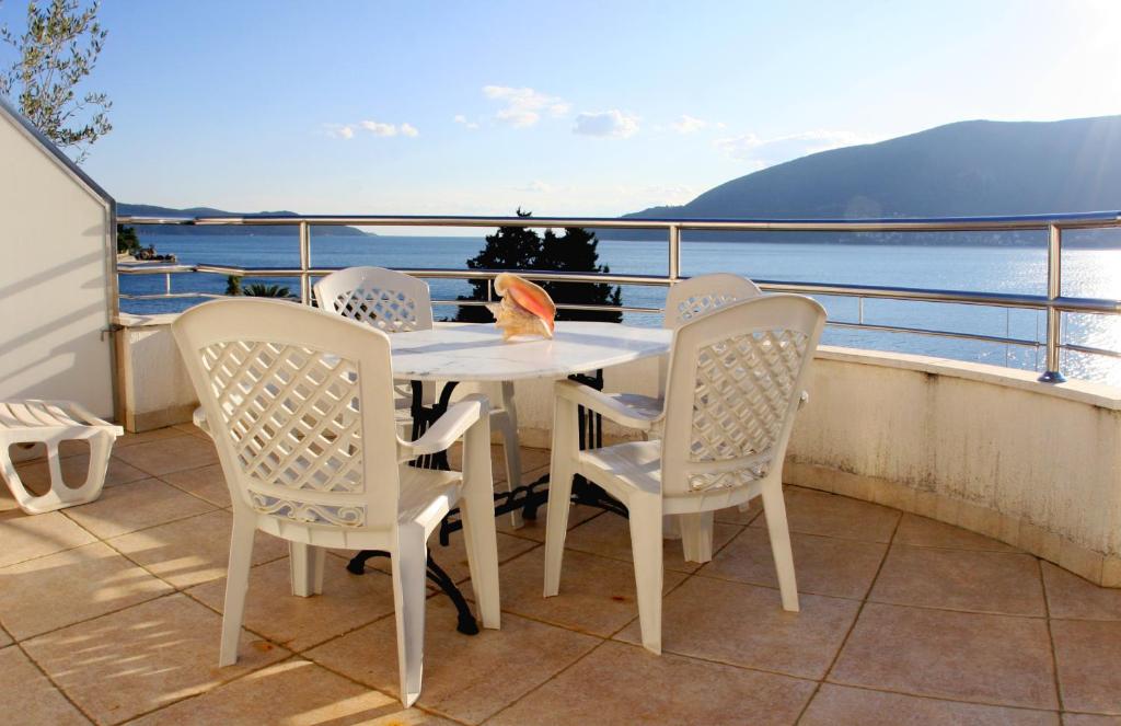 赫尔采格诺维Apartments Villa Kukoljac的阳台配有桌椅,享有水景