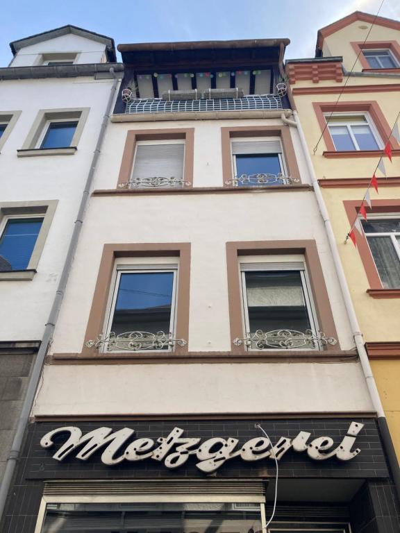 摩泽尔河畔的泽尔Haus Alte Metzgerei的带有餐厅标志的建筑