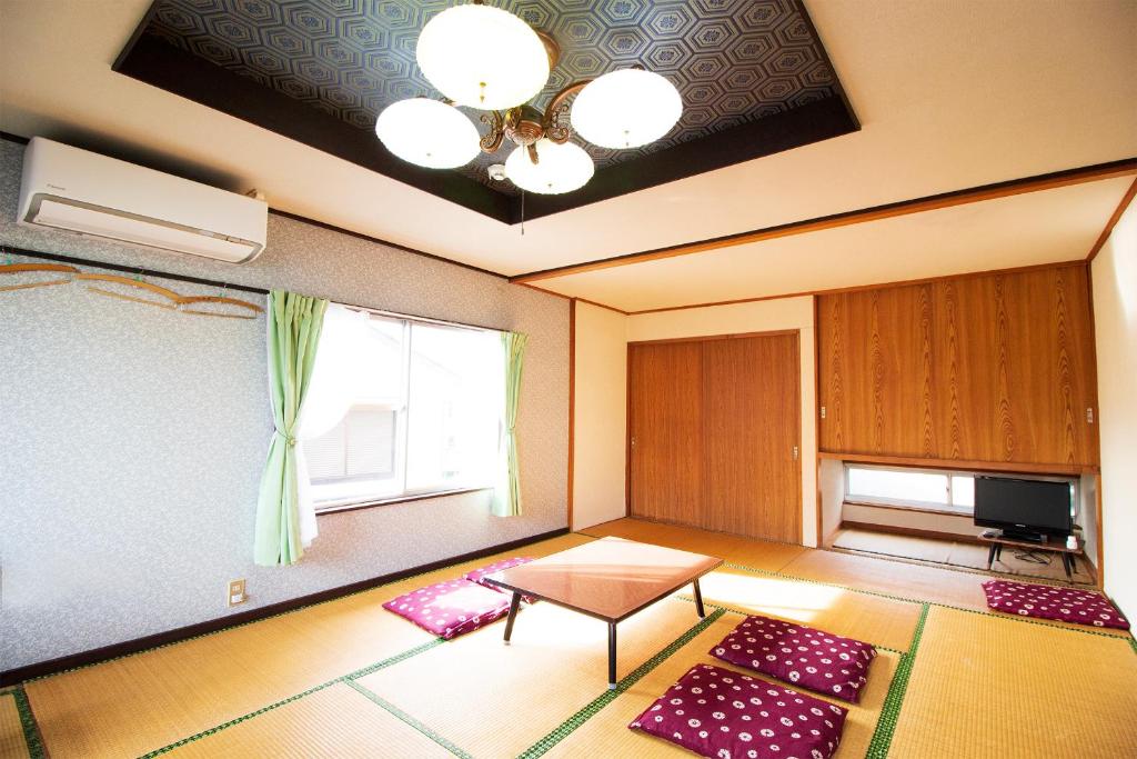 富士河口湖Habitacion NIIYA Mt Fuji的客厅配有桌子和窗户