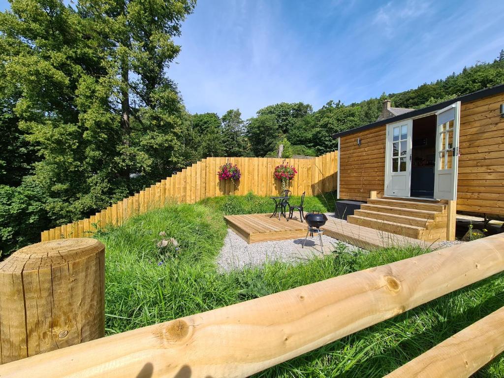 霍普Peak District Shepherds Hut的后院设有木栅栏和房屋