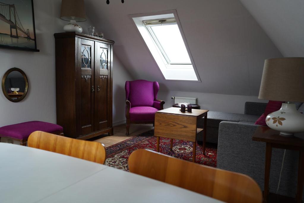哥本哈根Homely 2 room Apartment close to Copenhagen city center的客厅配有紫色椅子和沙发