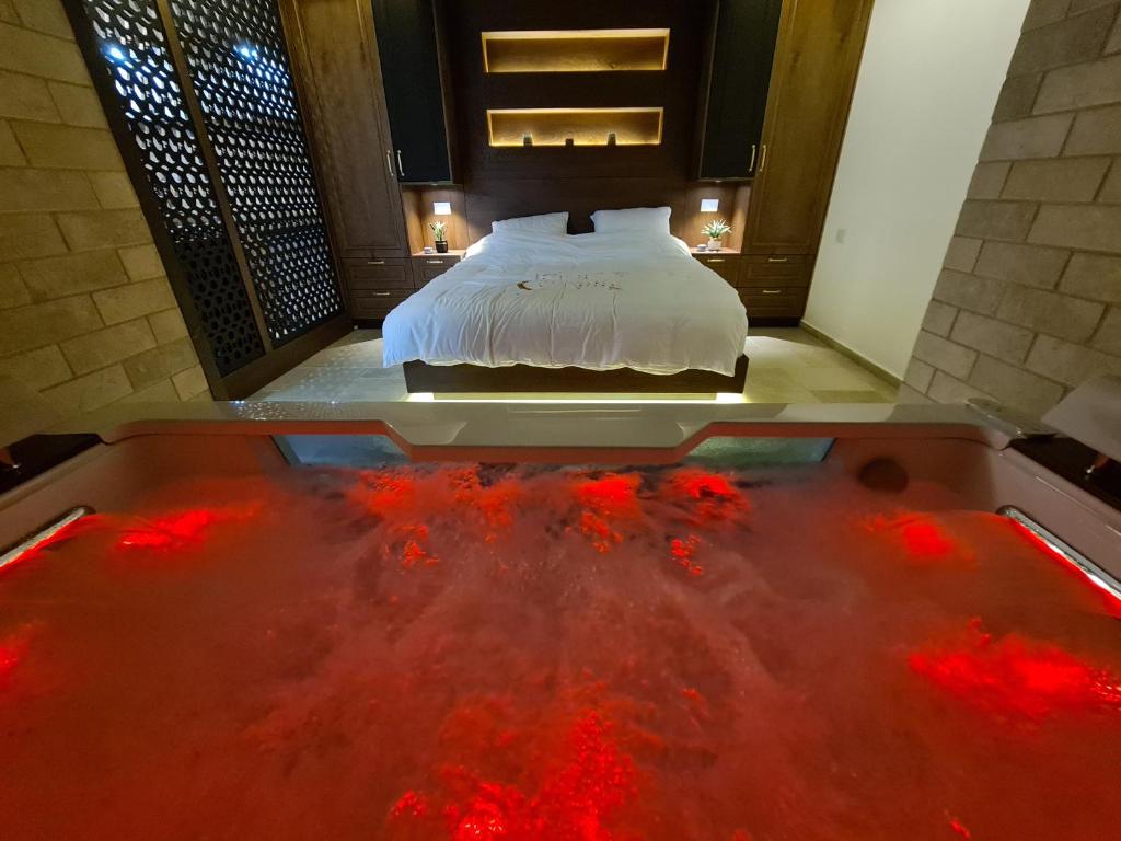 迈季代勒舍姆斯סוויטת נור Noor Suite的一间卧室配有一张床和一个红水浴缸