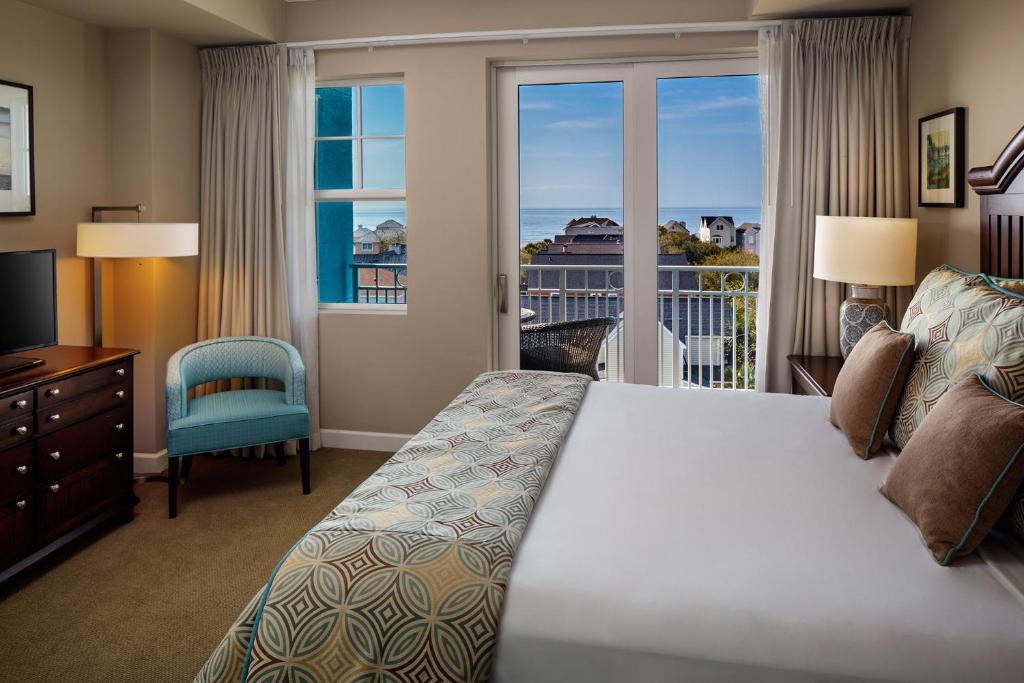 棕榈岛Wild Dunes Resort - Residences at Sweetgrass的一间卧室设有一张床和一个美景窗户。