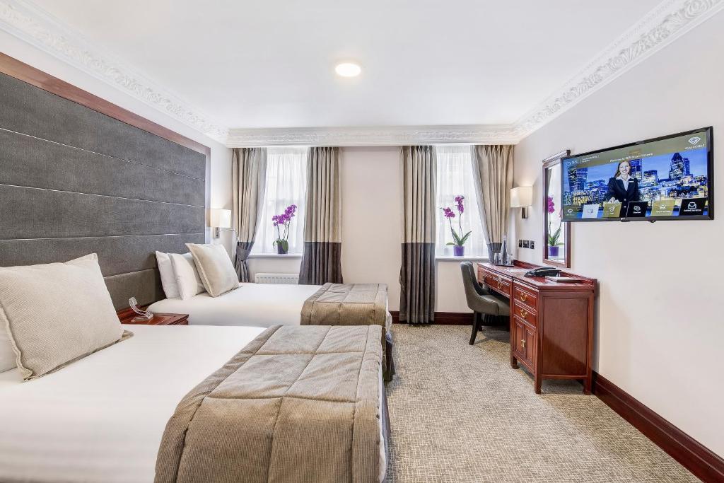 伦敦Gem Fitzrovia Hotel的酒店客房配有两张床和一张书桌