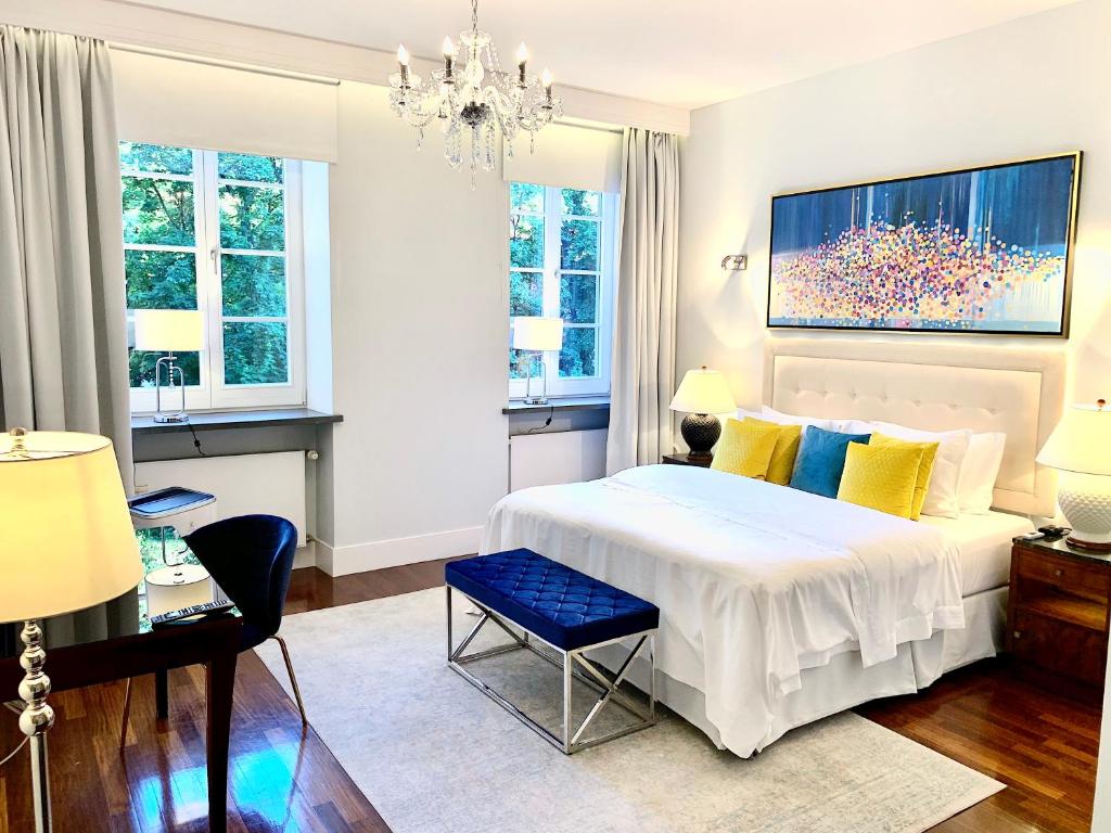 华沙MONDRIAN Luxury Suites & Apartments Market Square I的卧室配有一张白色大床和吊灯。