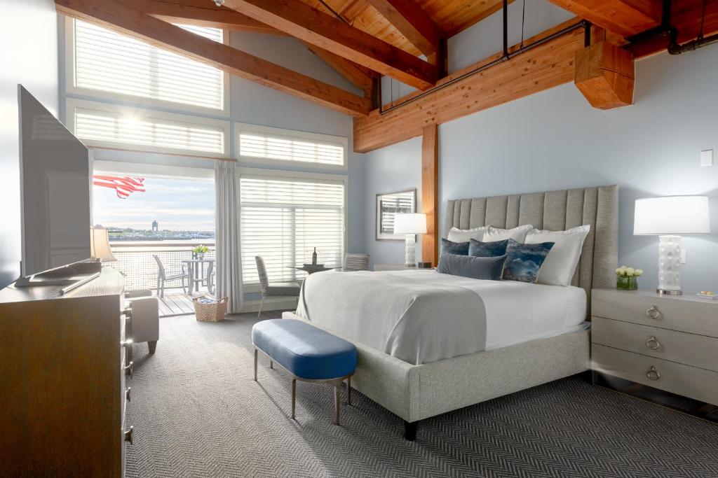 波士顿波士顿游艇天堂酒店的一间卧室配有一张大床和蓝色凳子