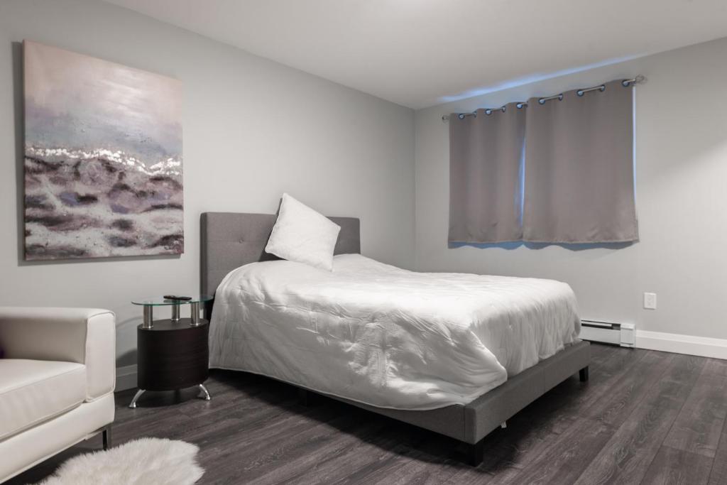 滑铁卢PRIVATE ROOM ENSUITE UPTOWN WATERLOO - e5的白色卧室配有床和沙发