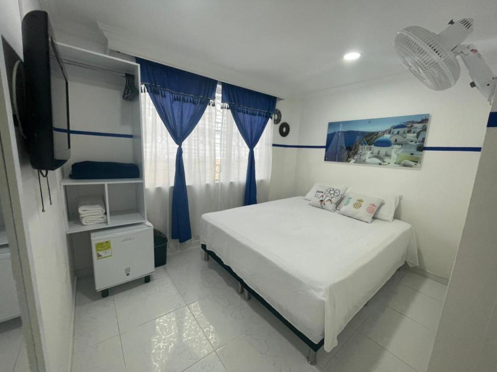 麦德林Casa Hotel Manco Mora的一间小卧室,配有一张床和电视