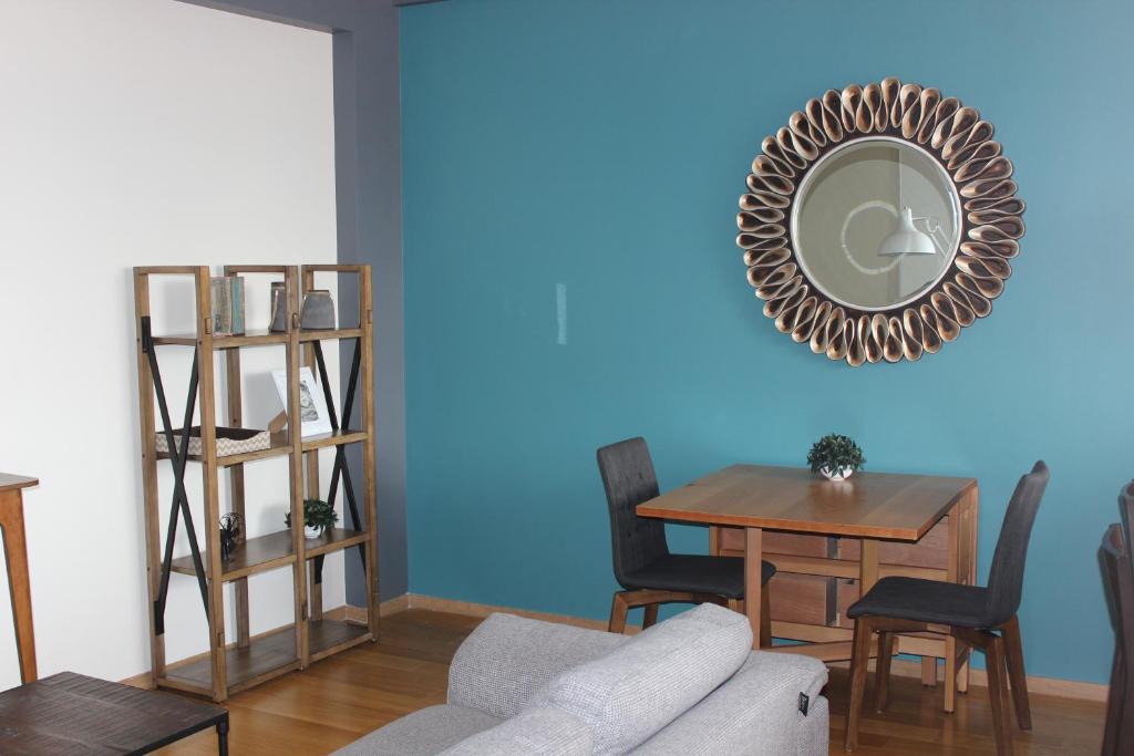 墨西哥城Downtown Mexico City, full apartment的客厅配有桌子和蓝墙镜子