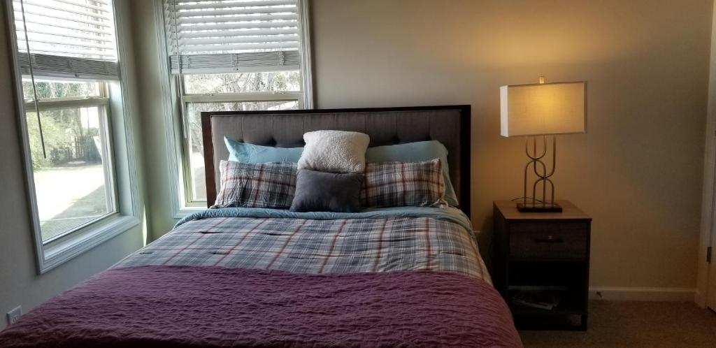 塔克Home at Tucker的一间卧室配有带枕头和台灯的床