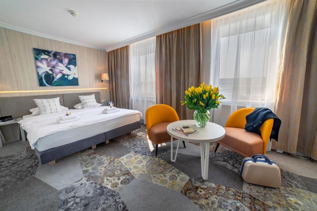 卢布林维多利亚酒店的酒店客房带一张床、一张桌子和椅子
