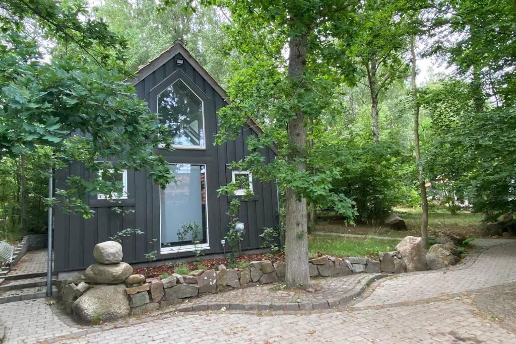 伦讷Oak Cottage near Rønne & Beach的一座黑色的小房子,有石墙