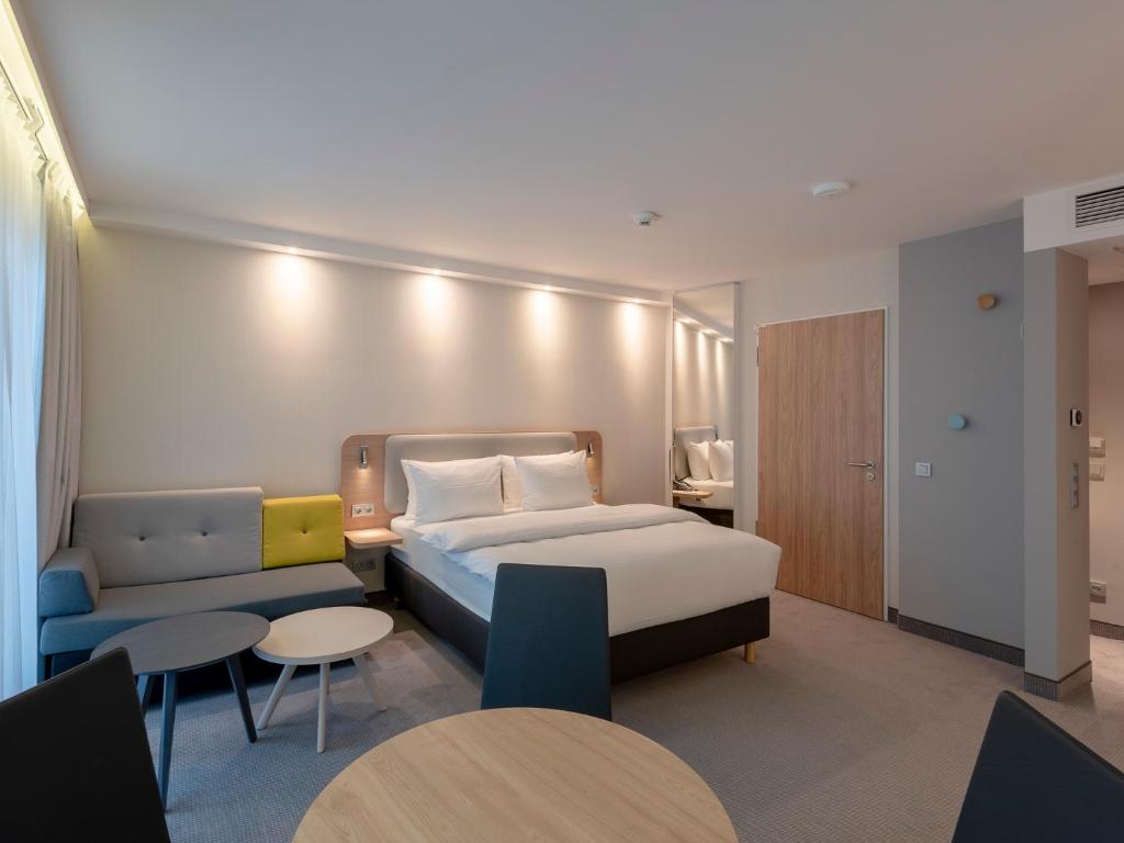 奥芬巴赫Holiday Inn Express - Offenbach, an IHG Hotel的酒店客房,配有床和沙发