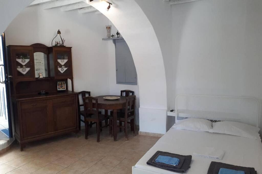 雷夫克斯Antigonis traditional house in lefkes village的一间卧室配有一张床和一张桌子及椅子