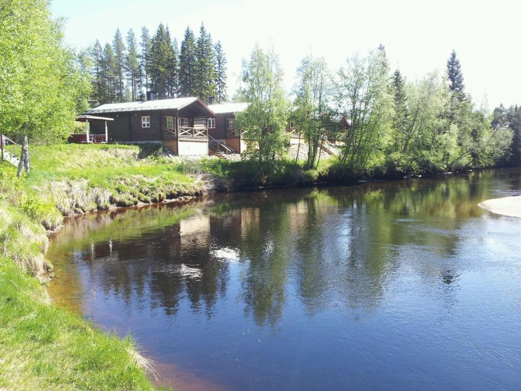 韦姆达伦Vålkojan Naturby - Timber cottages的河边的小木屋,有房子