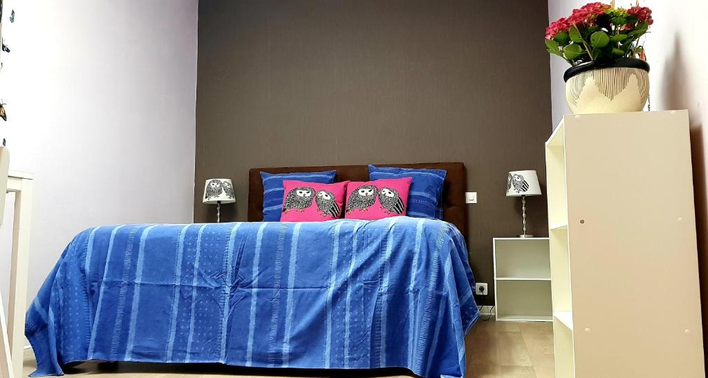艾马尔格Butterfly Bedroom in Sweet Home的一间卧室配有蓝色的床和2个粉红色枕头