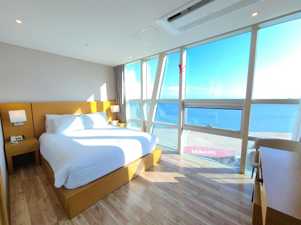 釜山海云台MS酒店的一间卧室设有一张床,享有海景