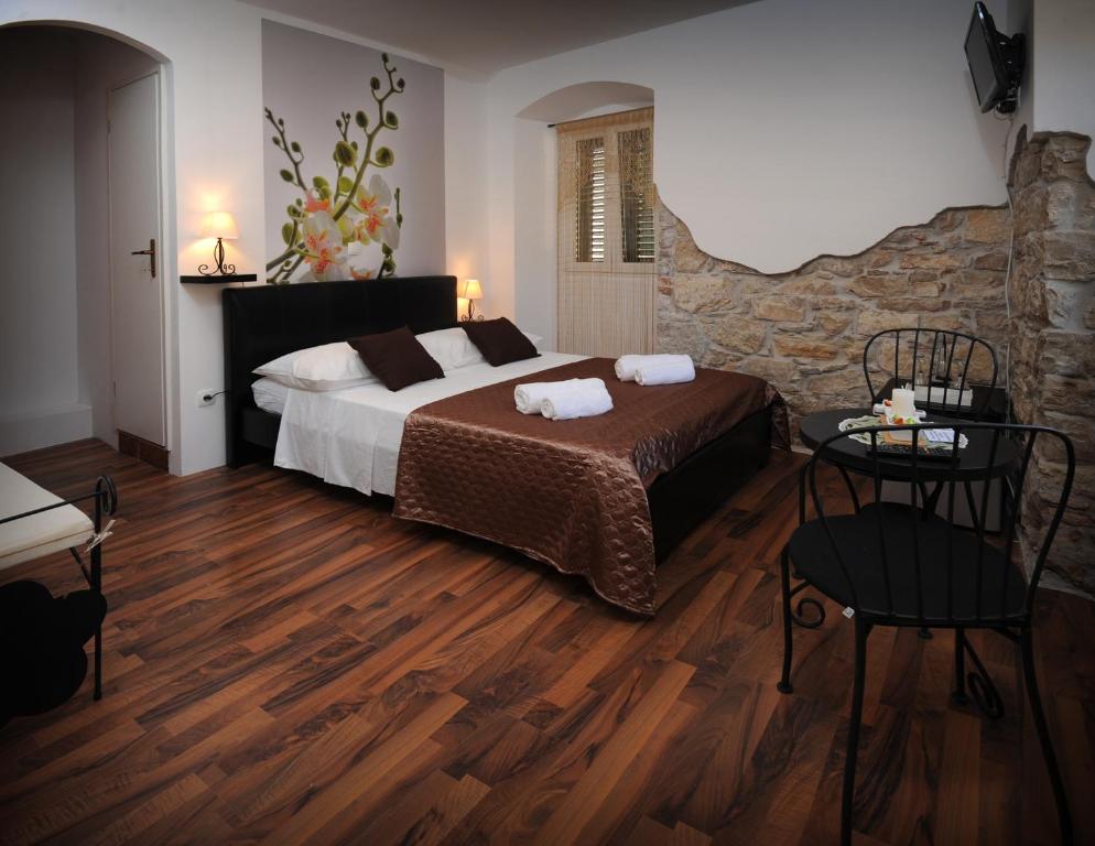 斯普利特拉斯塔客房公寓酒店的一间卧室设有一张大床和石墙