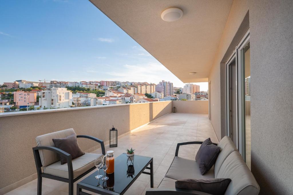 斯普利特New luxury 3-bedroom penthouse with huge terrace的阳台设有带沙发和椅子的客厅
