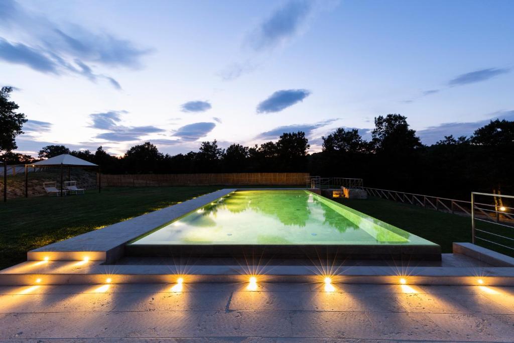 特雷宽达Il Giuncheto的游泳池在晚上点亮,灯光照亮